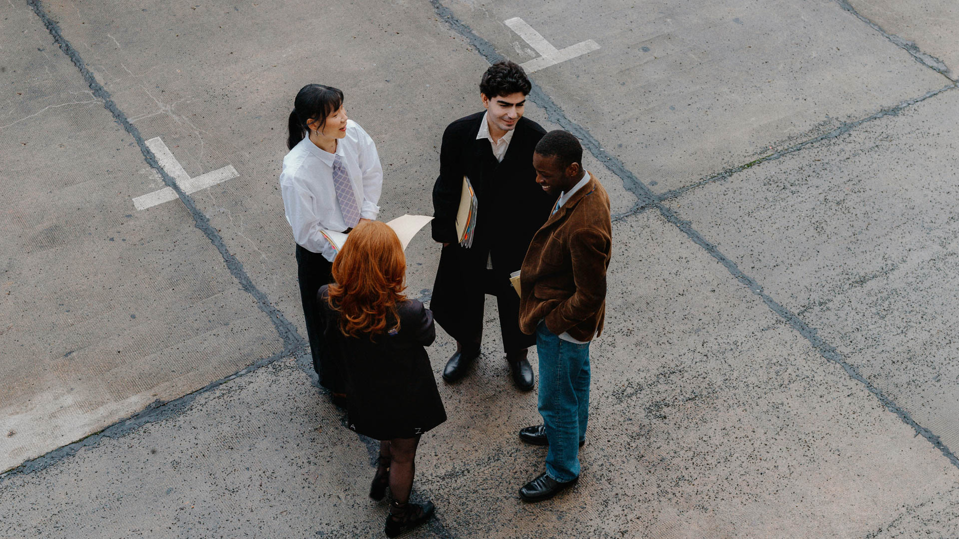 a group of people standing in a parking lot