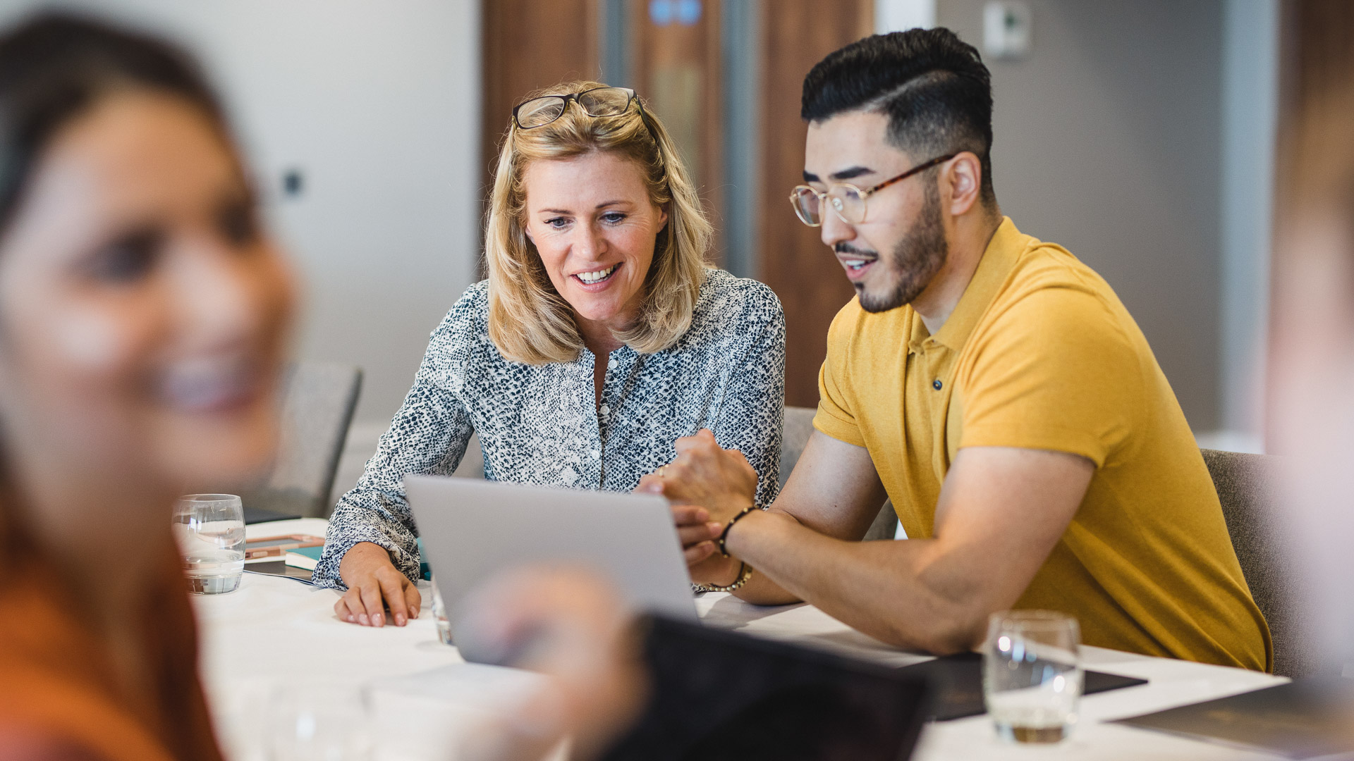 a man and woman looking at a laptop