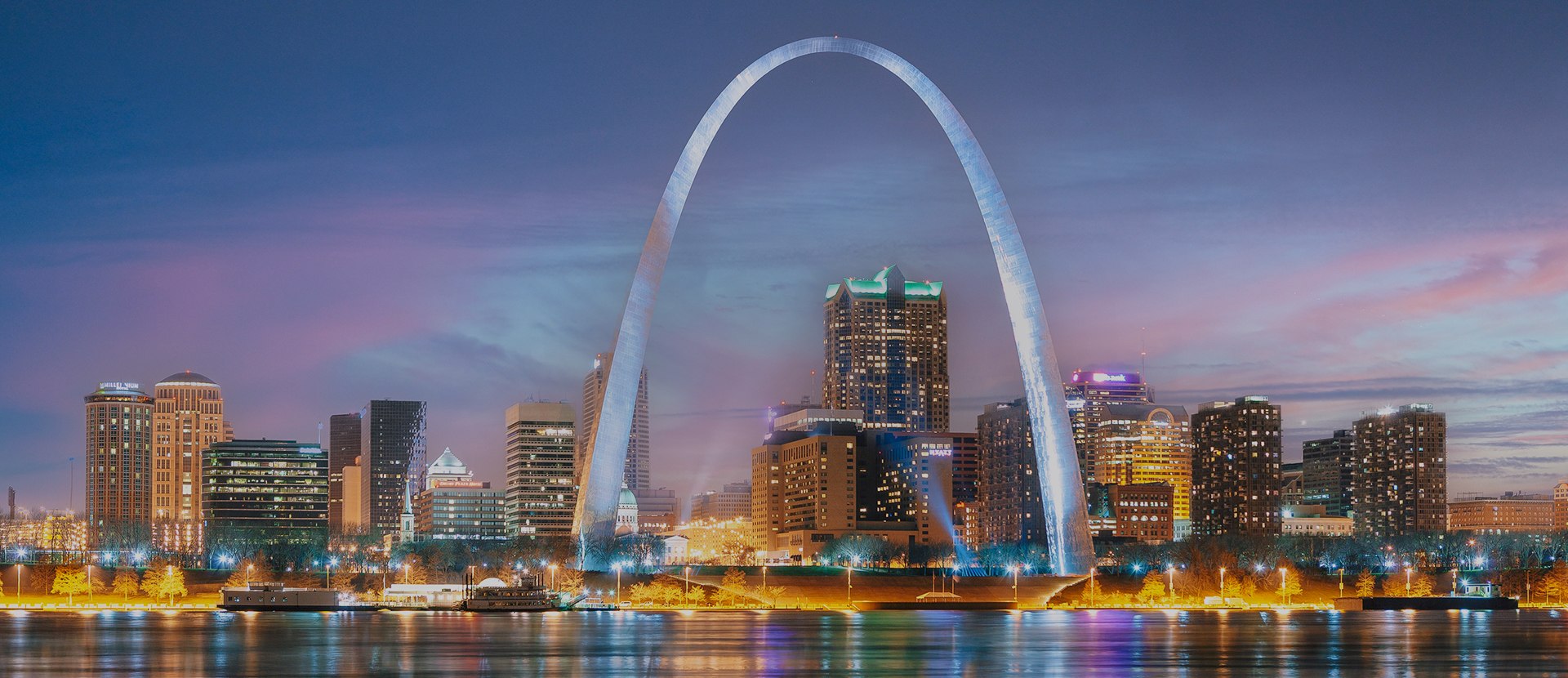 a large arch over water with city skyline in the background with Gateway Arch in the background