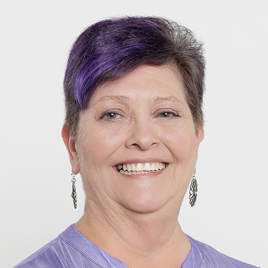 a woman with purple hair smiling