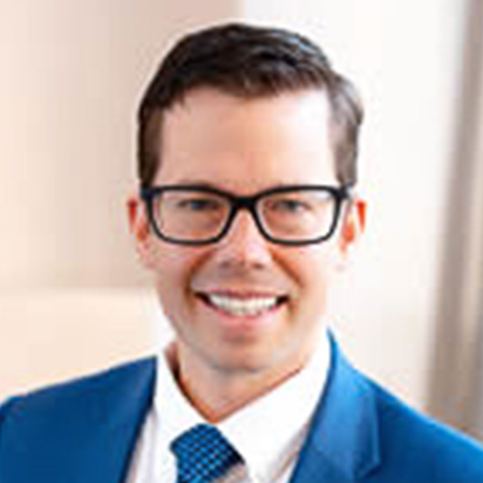 a man in a blue suit and glasses