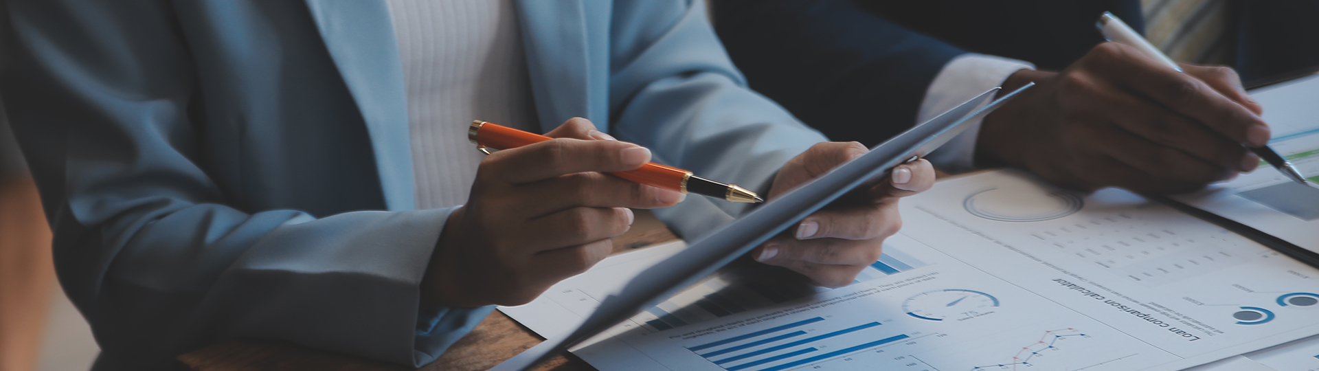 a person holding a pen and looking at a paper