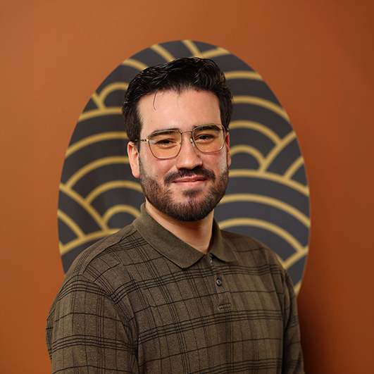 a man wearing glasses and a brown shirt