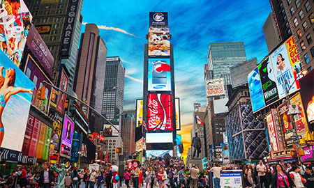 a group of people walking in a busy city with Times Square in the background