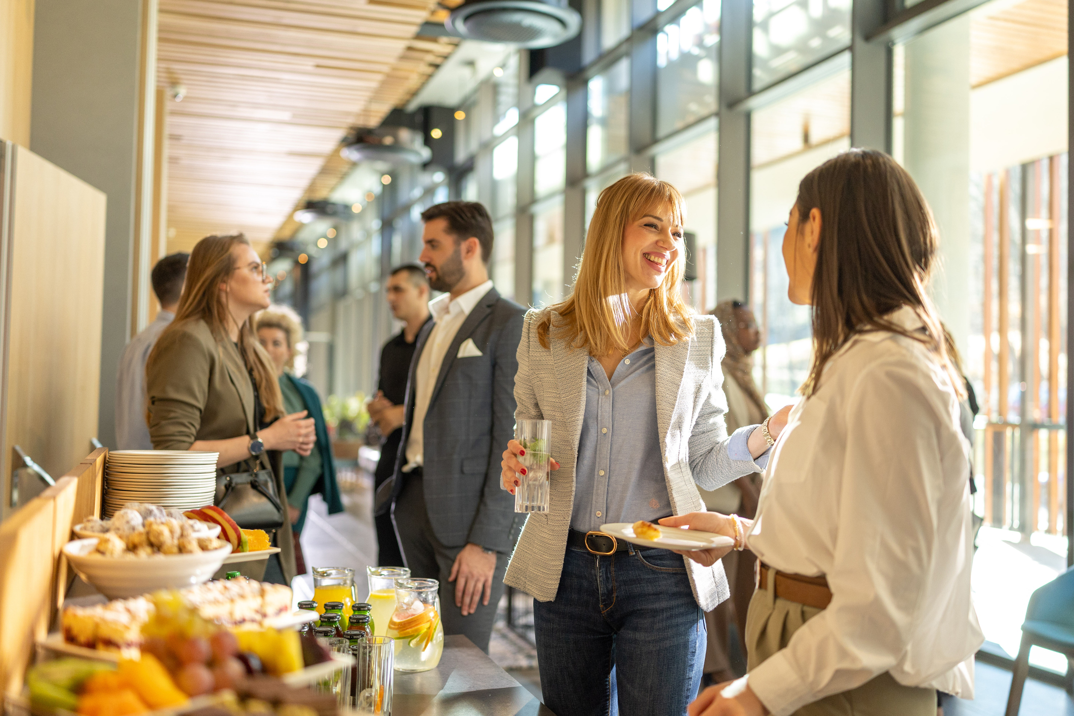 a group of people standing in a room with food and drinks