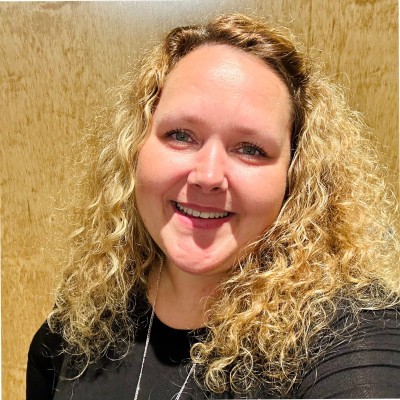 a woman with blonde curly hair smiling