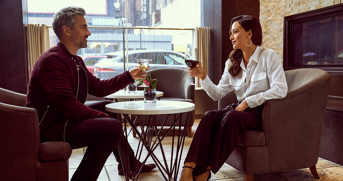 man and woman talking with glass of wine