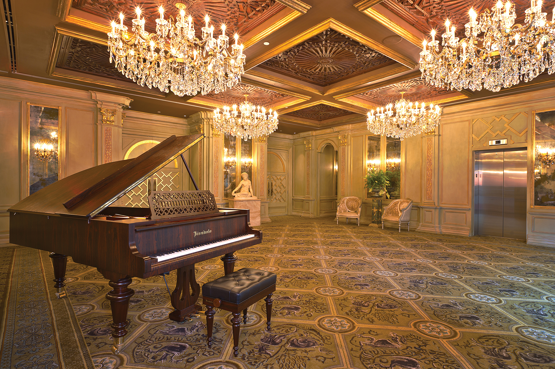 a piano in a room with chandeliers
