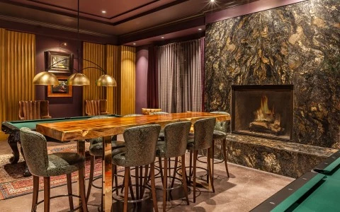 a pool table with chairs around it