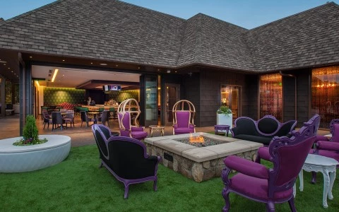 a patio with purple chairs and tables