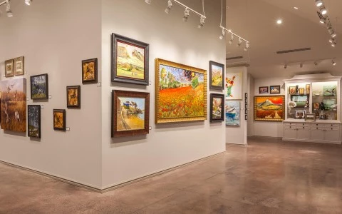 a room with many paintings on the wall