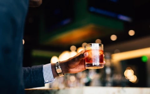 a hand holding a glass of liquid