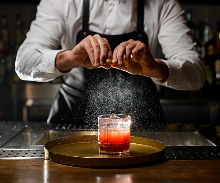 a person pouring a liquid into a glass