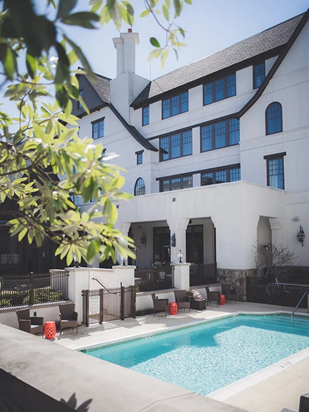 a swimming pool in front of a white building