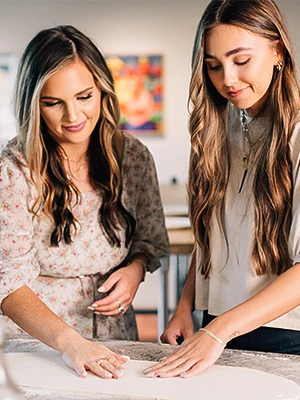 a couple of women looking at a paper