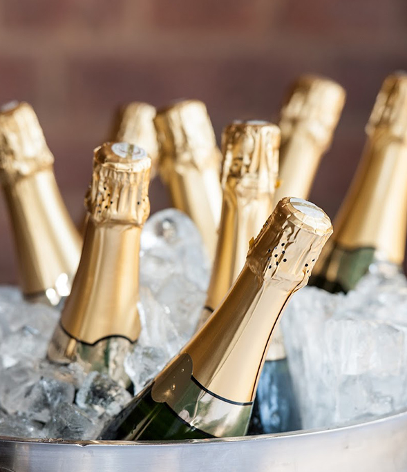 Gold and black champagne bottles in a bucket of ice