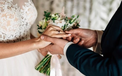 Groom placing ring on brides finger 