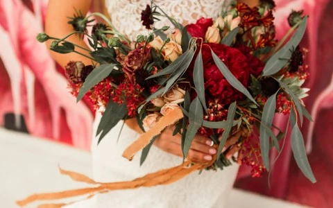 a woman holding a bouquet of flowers in a wedding dress