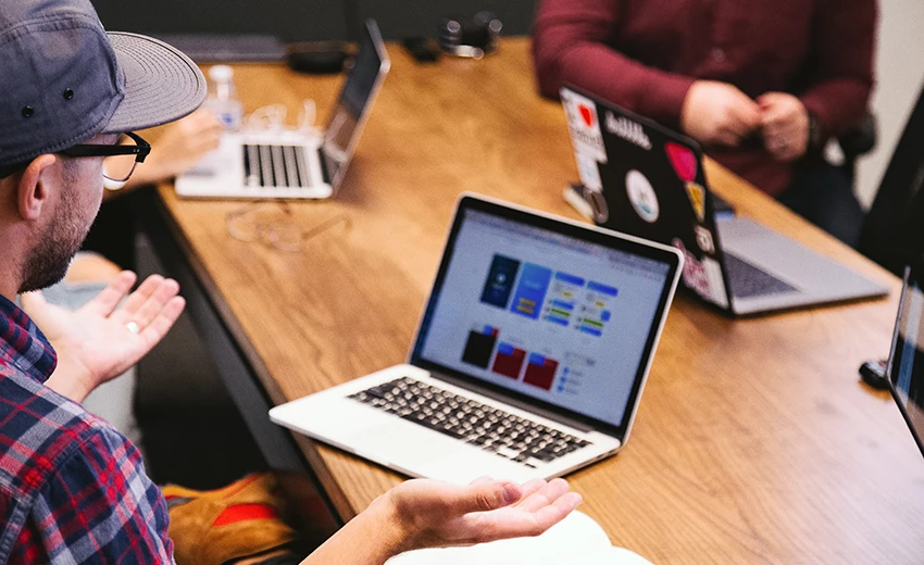 long work desk with people working on their laptops