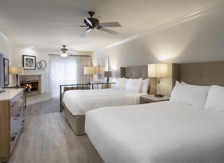 a room with two beds and a fireplace