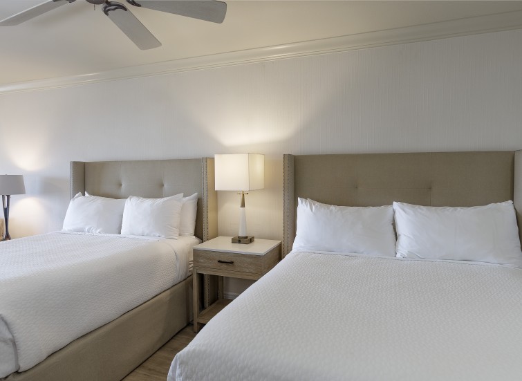a room with two beds and a fan