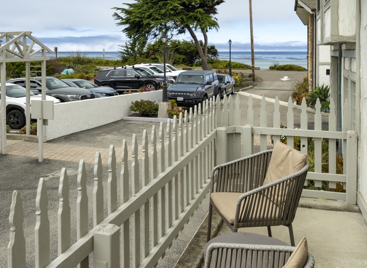 a white fence and chairs on a patio