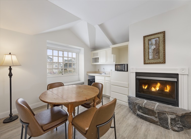a room with a table and chairs and a fireplace