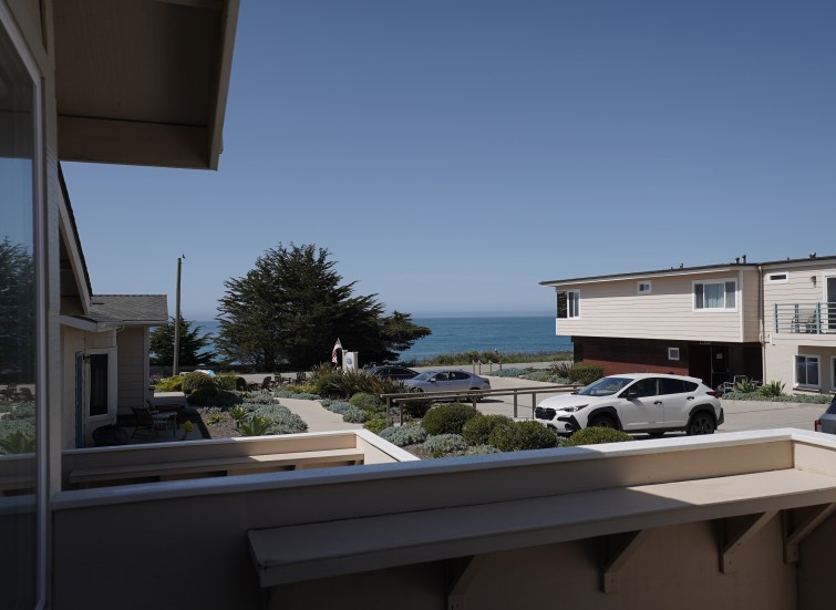 a view of a beach from a balcony of a house