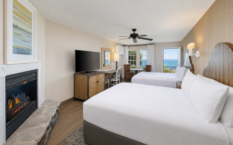 a room with two beds and a fireplace