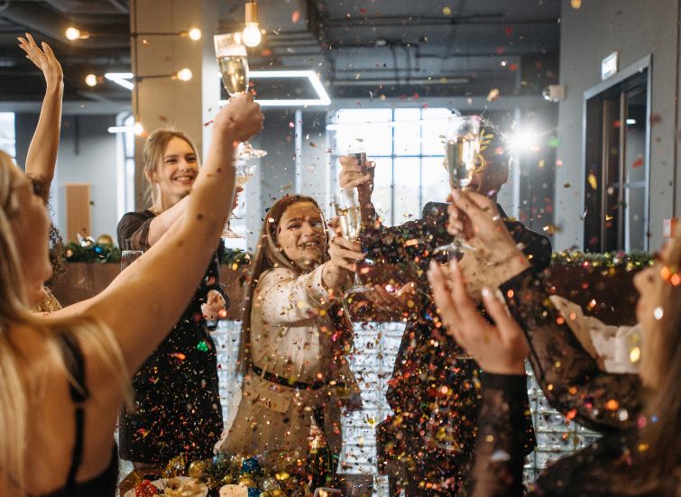 a group of people holding glasses with confetti