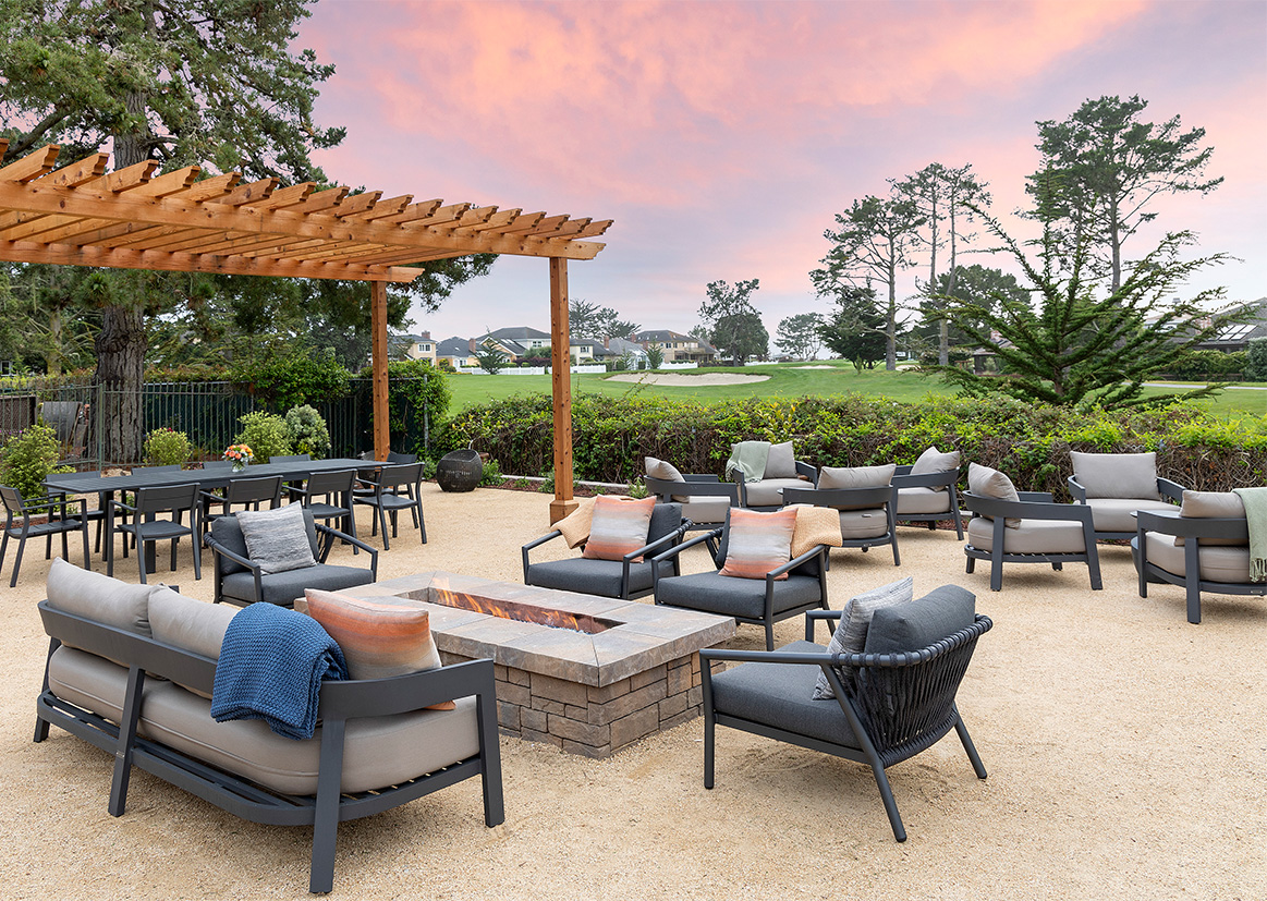 a patio with chairs and a fire pit