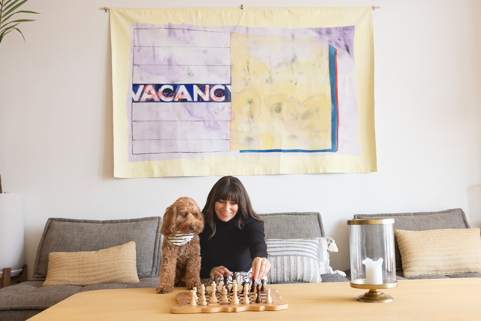 a woman playing chess with a dog