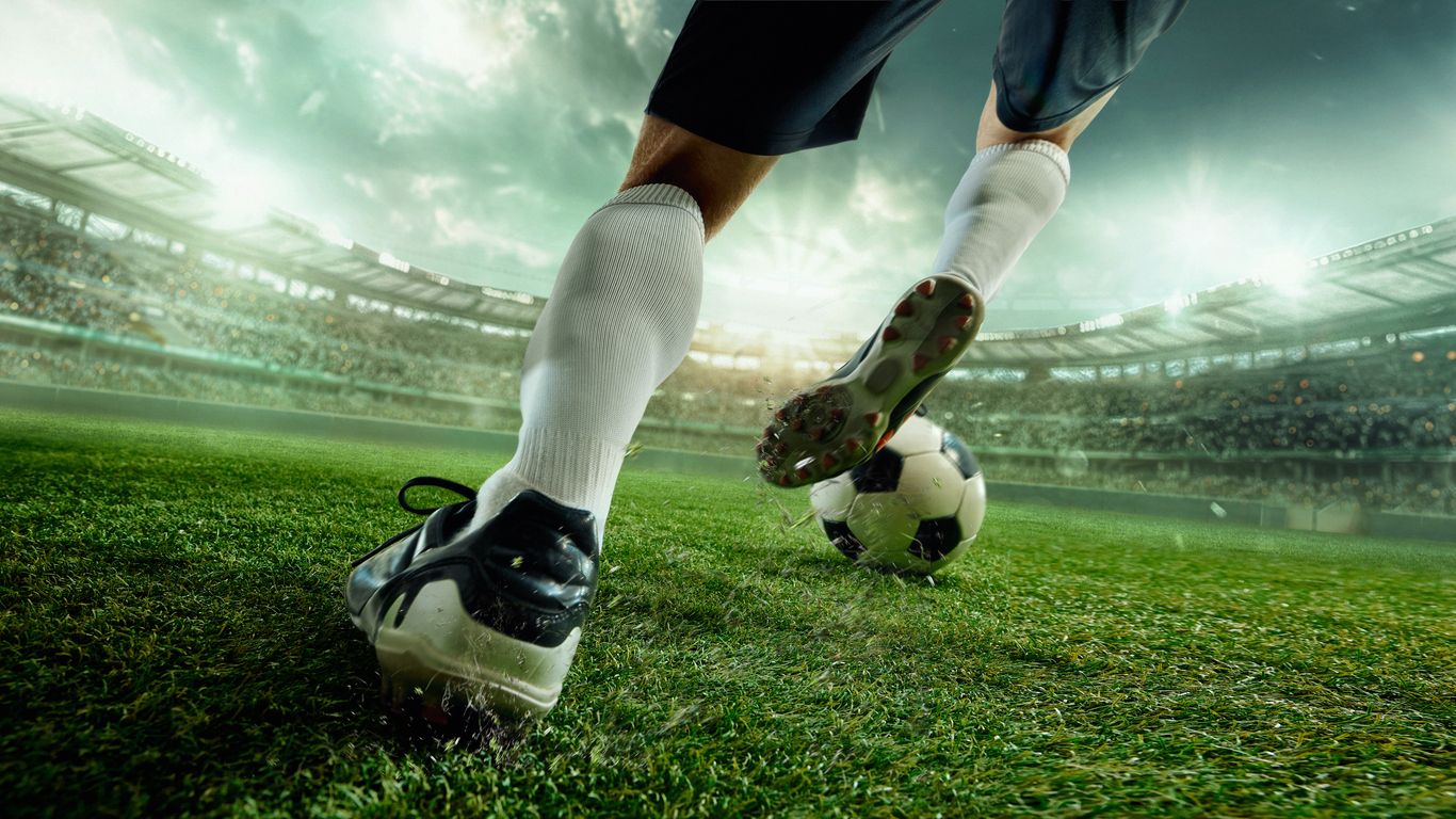 a football player kicking a football ball
