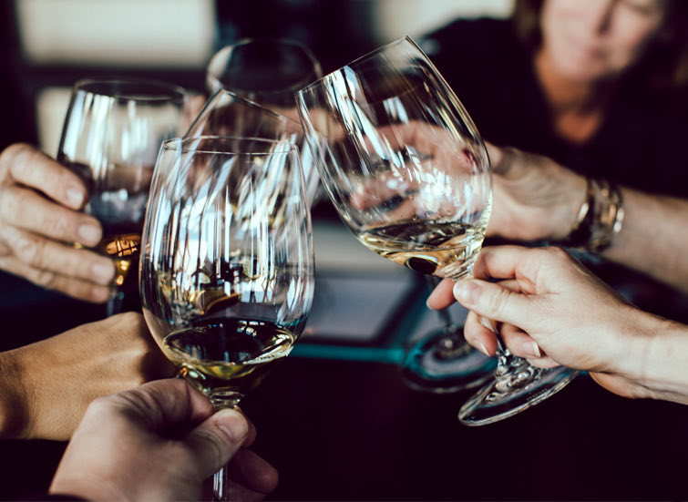 a group of people clinking wine glasses