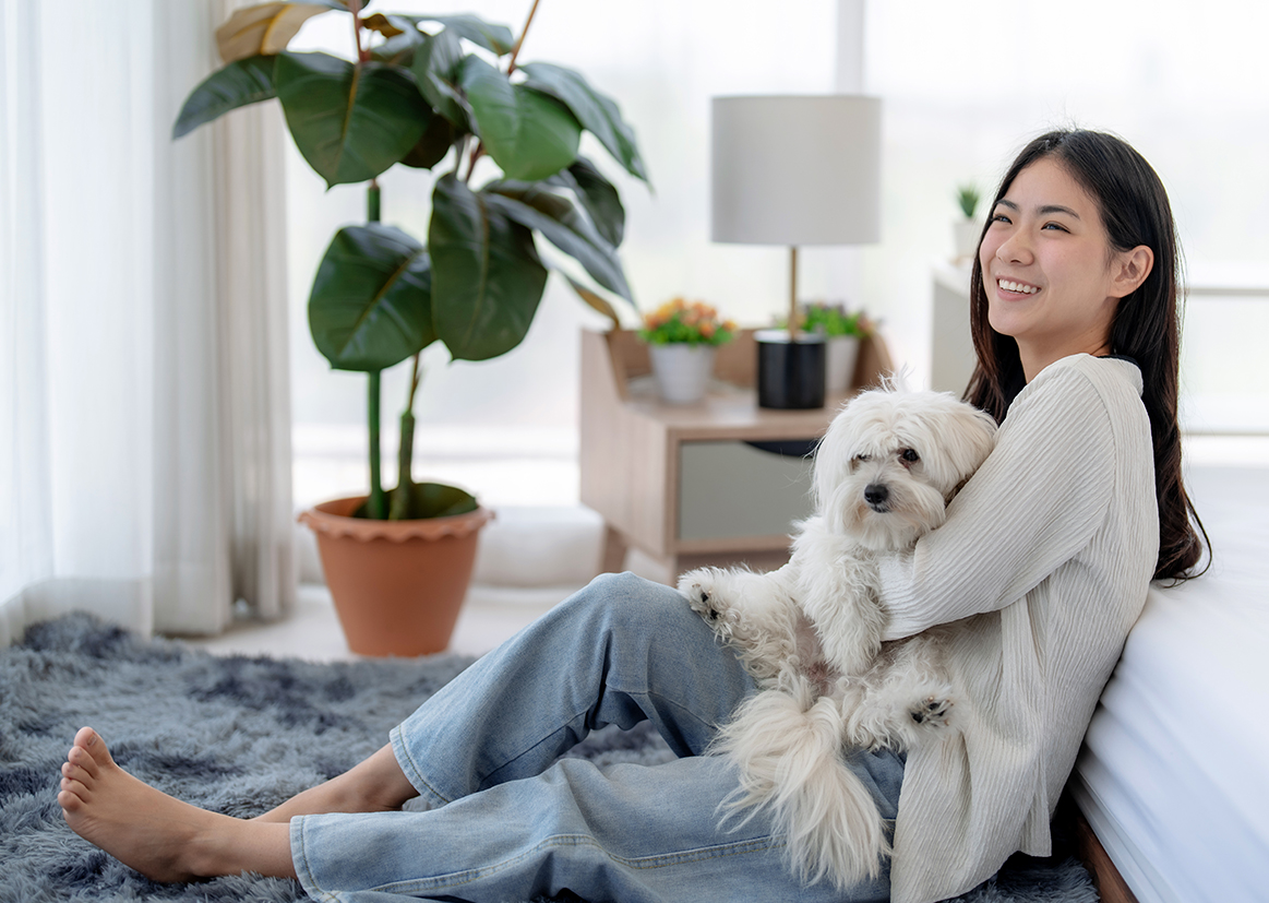a woman sitting on a rug holding a dog