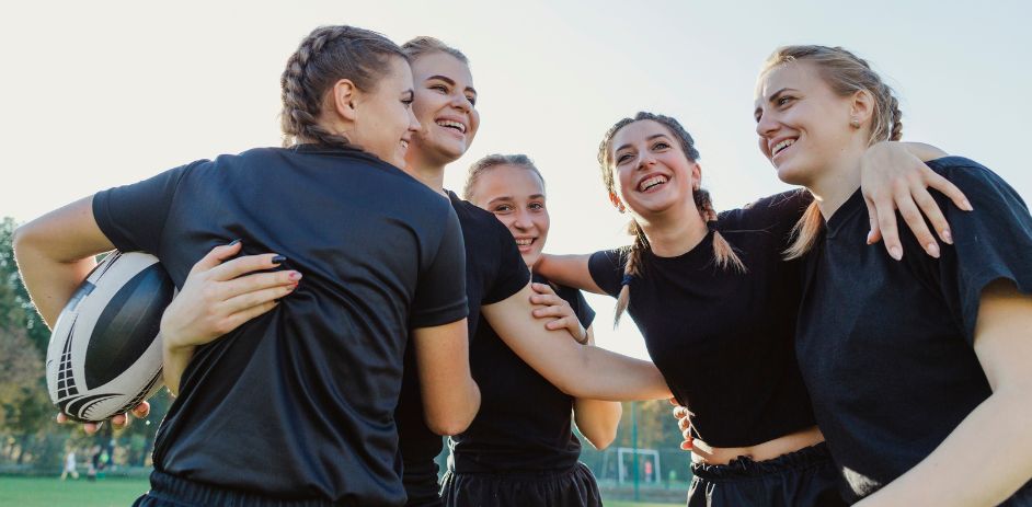 a group of women in black shirts hugging each other