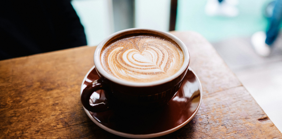 a cup of coffee with a heart design in the foam