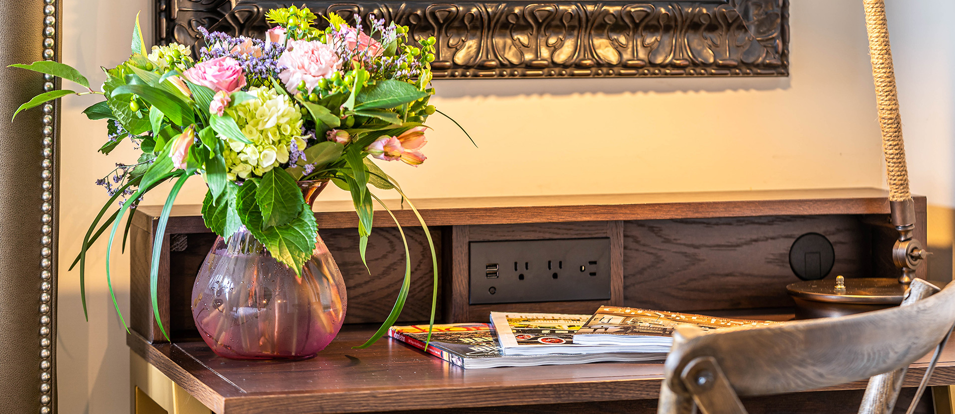 desk with plugs and a vase with flowers