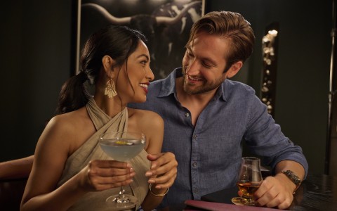 a man and woman both holding a drink