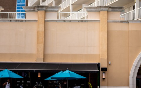 a pool with chairs and umbrellas in front of a building