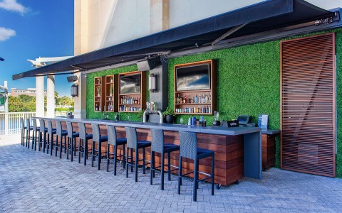 outdoor bar area with wooden features and black chairs
