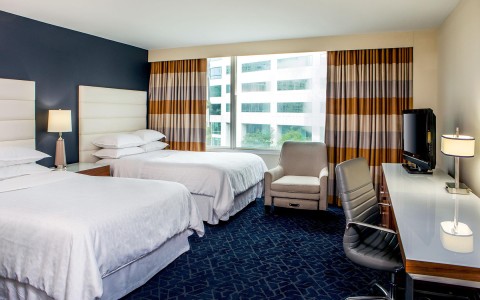 a hotel room with two beds and a desk
