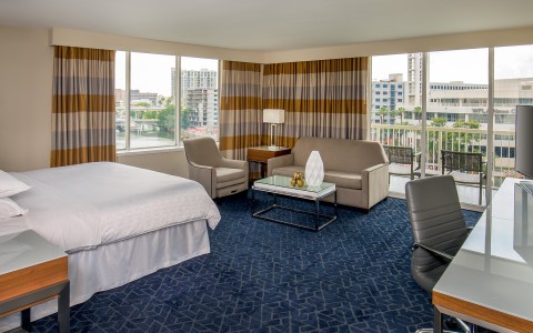 a room with a bed and chairs