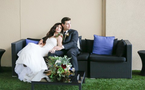 bride leaning into the groom on the couch