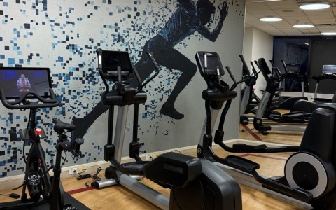 a room with exercise bikes and a wall mural