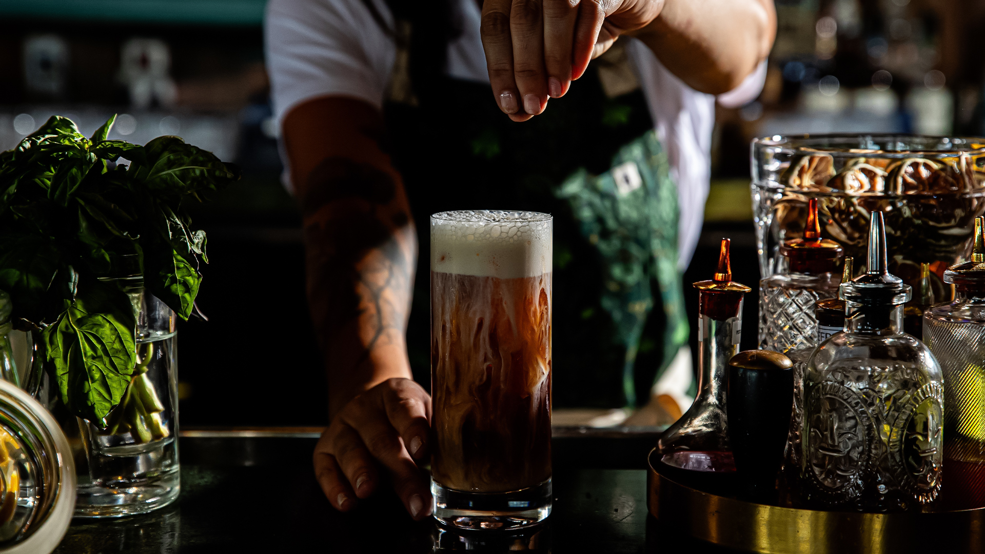 a person adding a drink into a glass