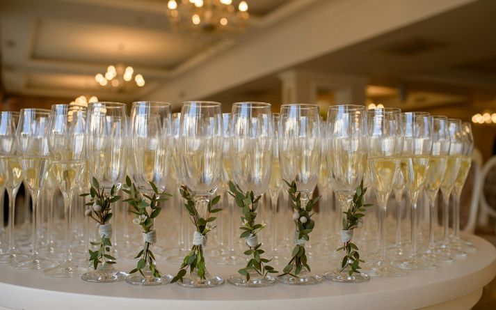 a row of champagne glasses with leaves on them