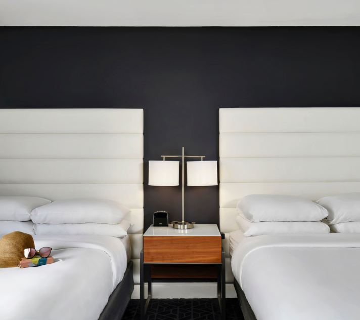 a room with two beds and a table with a lamp