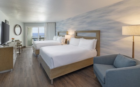 a room with two beds and a chair