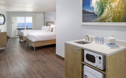 a room with two beds and a sink